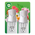 Two white Air Wick plug-in oil warmers shown on green floral backing card with brand logo at top left.