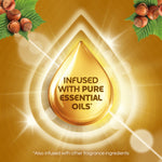 Gold droplet graphic with text 'Infused with pure essential oils' set against a warm background and hazelnut accents