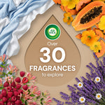 Promotional graphic with Air Wick logo and text "Over 30 Fragrances to explore" surrounded by flowers and fruit imagery