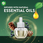 Air Wick refill bottle with pine cones and juniper berries, text stating infused with natural essential oils
