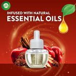 Single Air Wick scented oil refill against red background with apples, cinnamon and a droplet graphic labeled infused with natural essential oils