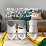 Three Air Wick scented oil devices displayed on a living room rug with text about refill compatibility