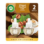 Air Wick cozy collection blister pack showing two Whipped Hazelnut Latte plug‑in refill bottles with hazelnuts and whipped topping artwork
