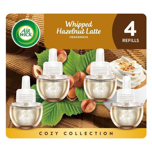 Air Wick branded blister pack showing four whipped hazelnut latte plug-in oil refill bottles with hazelnuts and whipped cream imagery
