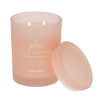 Lit Allswell Glow frosted spa jar candle labeled vanilla • pear • coconut with removable lid leaning at its side.