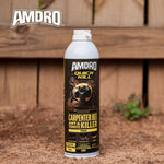 AMDRO Quick Kill foam can placed on dirt with a wooden fence background, showing the product label with a large bee image.