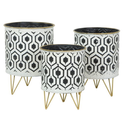Three white metal round planters with black geometric hexagon pattern on gold hairpin legs, studio view