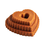 Golden-brown tiered heart cake angled on white background showing scalloped layers and heart-shaped center hole