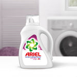 Ariel Ultra Concentrado detergent bottle on a surface with a blurred washer and laundry background, studio-style product shot.