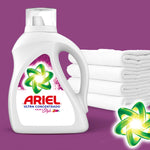 Ariel Ultra Concentrado detergent bottle beside stacked white towels on a purple background with green swirl logo accent.