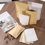 Assorted kraft and white stand-up resealable pouches displayed on a wood table with a magazine and scattered nuts