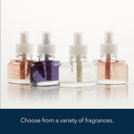 Four different Yankee Candle ScentPlug refill bottles in a row showing various liquid colors, photographed on a reflective white surface.
