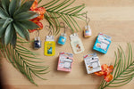 Assortment of Yankee Candle Car Jar air fresheners and packaged car vent clips arranged on a wooden surface with green leaves