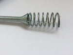 Close-up detail of a metal drain auger spring tip and coiled cable on a white surface, showing the spiral end