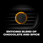 Close-up of AXE round vent clip mounted on a car grille with bold text about chocolate and spice scent