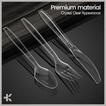 Stylized product image of a clear plastic spoon, fork and serrated knife arranged on a reflective dark surface with 'crystal clear' text.