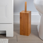 Tall square bamboo toilet brush holder with wooden handle placed beside a toilet in bathroom scene