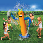 Children playing around a tall orange inflatable sprinkler spraying water on a grassy lawn