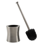Stainless steel hourglass toilet brush holder with the brush angled outward, showing metal handle and dense black bristles