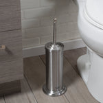 Stainless steel toilet brush holder with lid and decorative handle positioned beside a toilet in a tiled bathroom