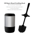Matte black-handled toilet brush with round bristle head displayed next to its stainless-steel holder with black base and instructional text.