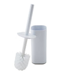 White acrylic rectangular toilet brush holder with brush removed and angled to show round bristle head and protective splash guard