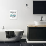 Bathroom interior scene with a small framed Cotton Co. truck wall plaque hung above a bathtub and next to a sink.