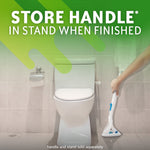Bathroom scene with a toilet and a hand placing a Scrubbing Bubbles wand into a triangular stand beside the bowl