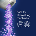 Illustration of purple scent booster beads pouring from a cap with text 'Safe for all washing machines' and washer icons