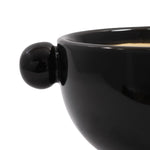 Close-up of a glossy charcoal ceramic planter showing one spherical knob handle and rounded rim detail