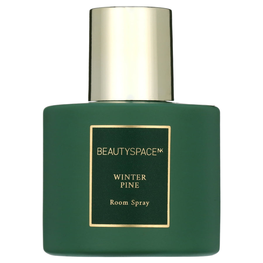 Green matte bottle of BEAUTYSPACE Winter Pine room spray with gold cap and label on white background