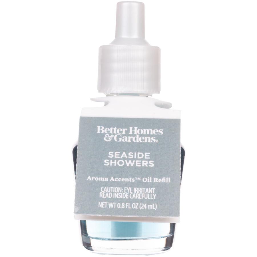 Clear glass refill bottle with pale blue oil and a white screw cap label reading Seaside Showers