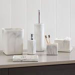 White faux marble bathroom accessory set including cylindrical toilet brush holder and coordinating pieces on counter
