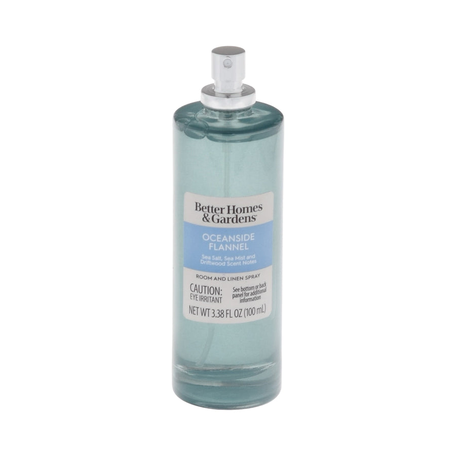 Tall cylindrical teal glass bottle of Better Homes & Gardens Oceanside Flannel room and linen spray with label and spray mechanism visible