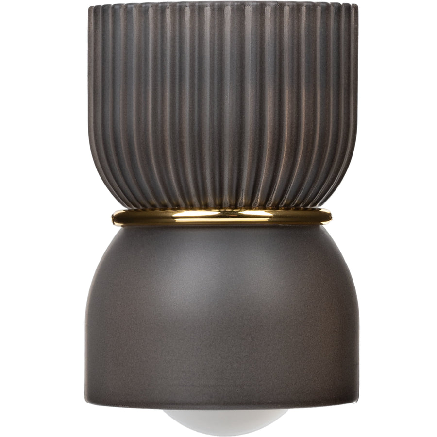 Close-up studio shot of a ribbed dark gray fragrance plug with gold trim and diffuser bulb