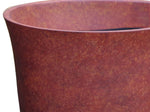 Close-up detail of rust-textured finish and flared rim of a rounded planter pot
