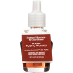 Single Better Homes & Gardens Warm Rustic Woods aroma accents oil refill bottle shown front-facing with visible label and pink liquid.