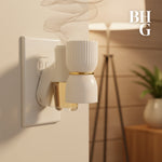 Plug-in fragrance diffuser inserted in a wall outlet with vaporized scent rising, styled room background and BHG logo.