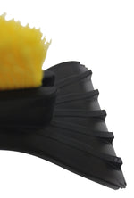 Detail shot of yellow brush bristles mounted on a black plastic scraper head