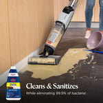 Upright BISSELL floor cleaner in use on a tile floor cleaning a large spill, with product bottle graphic and text overlay.