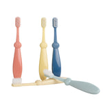Four pastel Bizzu training toothbrushes arranged on white background, two lying and three standing