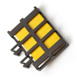 Close-up view of a black plastic grid cartridge holding yellow lure pads photographed on white background