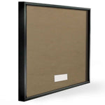 Rear view of a black picture frame showing brown kraft backing and a small white label area.