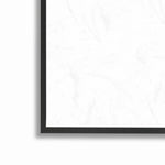 Close-up of a black picture frame corner showing a white textured print or mat inside the frame.