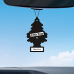 Little Trees Black Ice tree-shaped air freshener hanging from a car rearview mirror against a blue sky.