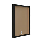 Angled view of a black shadowbox-style frame showing the brown backing board inside, representing the framed print's rear profile.