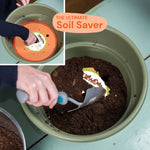 Hands using a trowel to add soil into a planter with an orange Ups-A-Daisy insert visible inside.