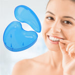 Open translucent blue heart-shaped retainer case floating beside smiling woman inserting a clear aligner into her teeth.