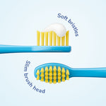 Close-up of a blue kids toothbrush head with yellow soft bristles and a dab of toothpaste, labeled slim brush head and soft bristles.