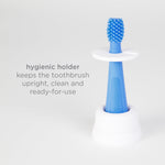 Blue silicone toothbrush inserted upright into a white hygienic holder with on-image text about the holder